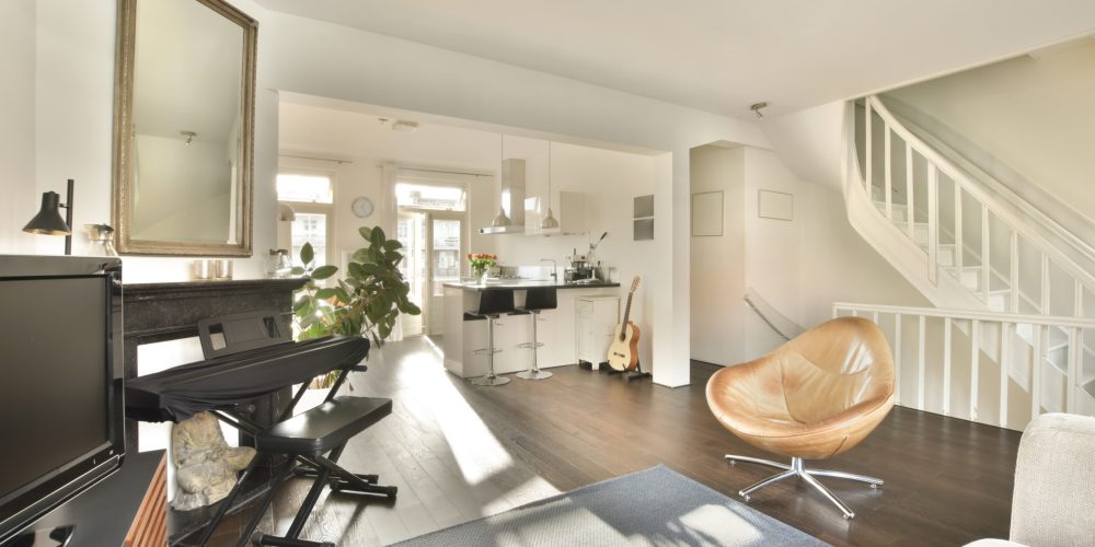 Comfortable sofa with cushions placed against light wall with decorations in modern living room